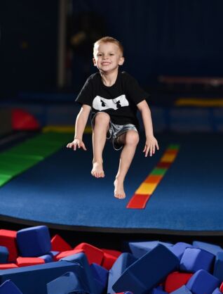 a boy jumping into a pit of foam blocks